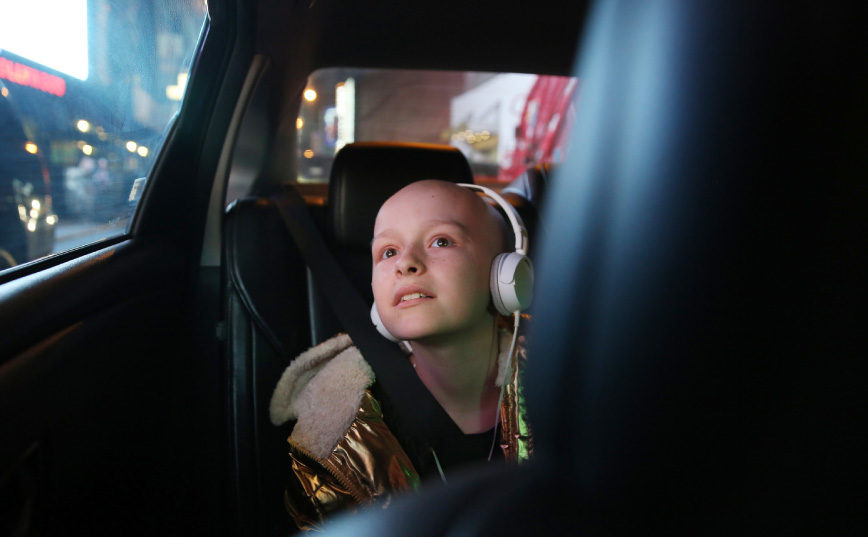 girl in car listening to music with pink headphones